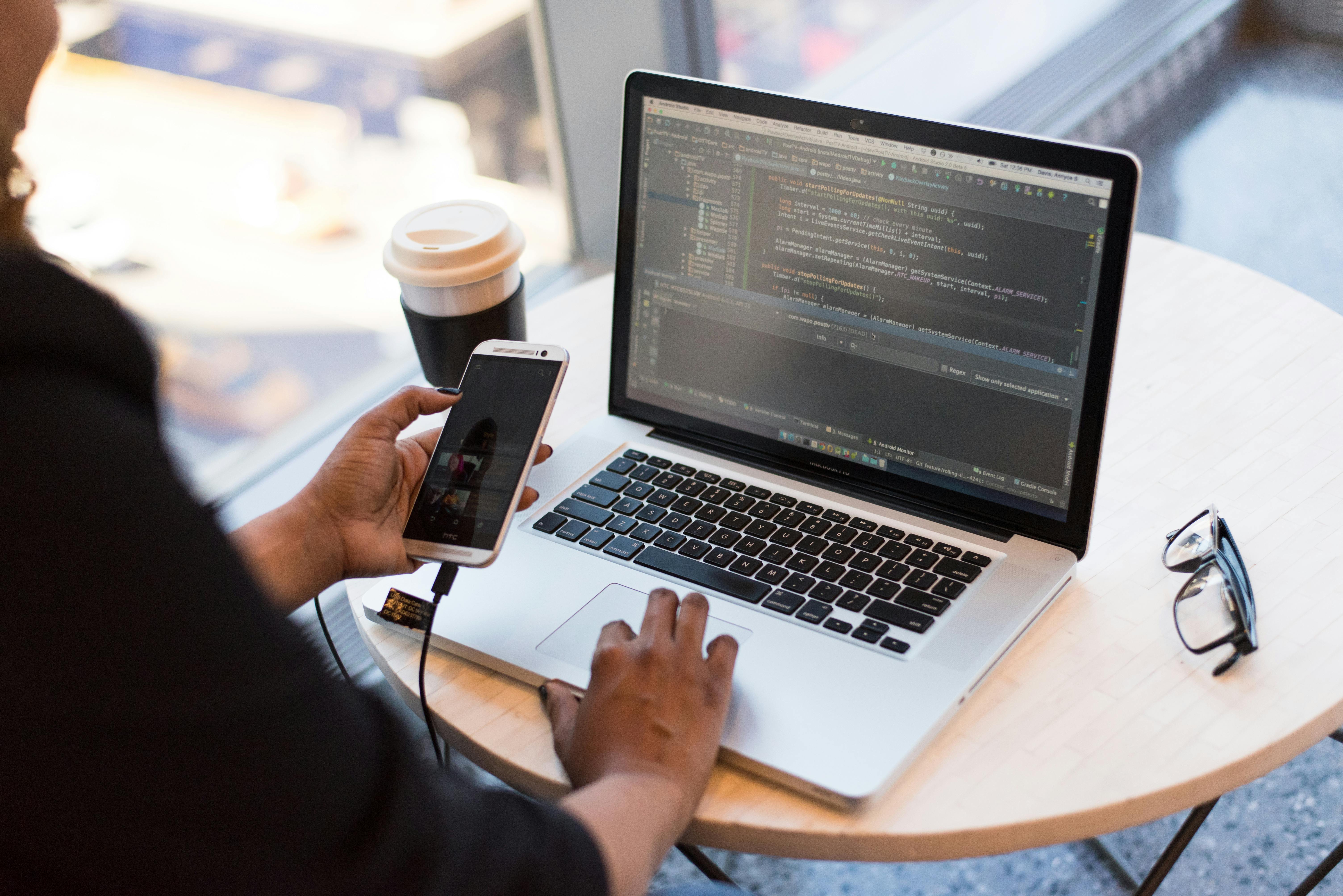 Developer writing code on multiple monitors in a dark office