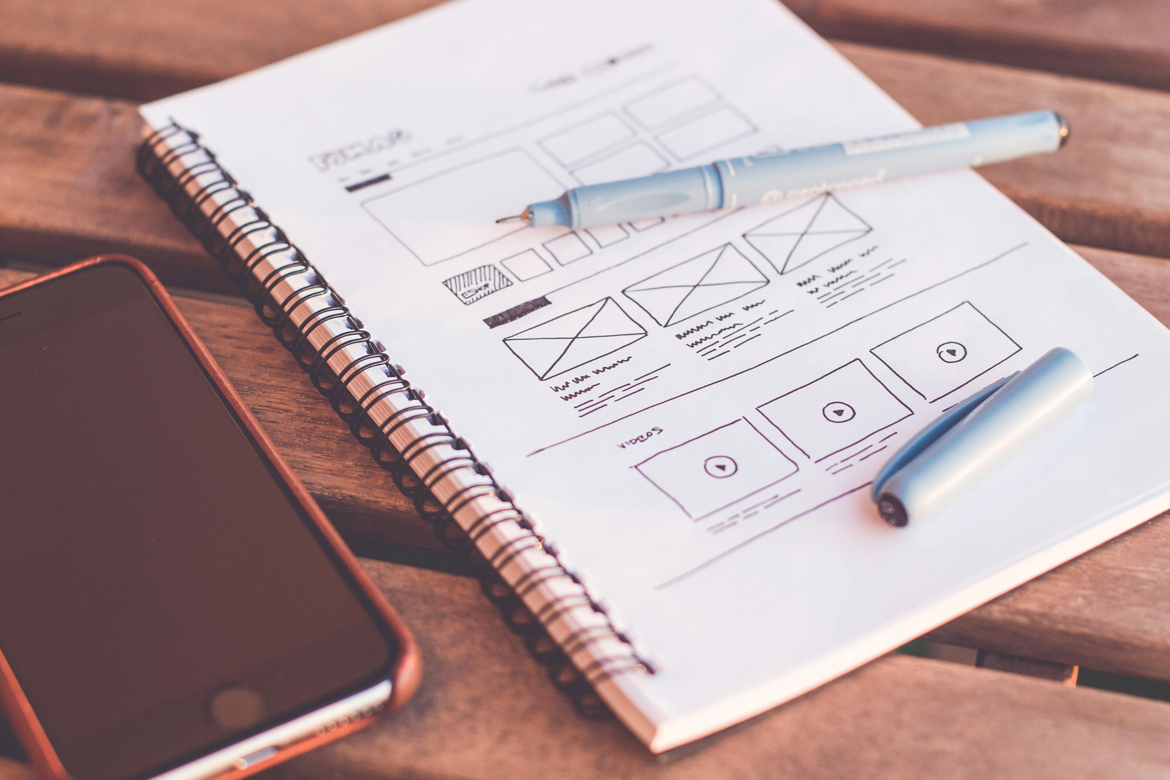 Designer sketching a website wireframe on a desk